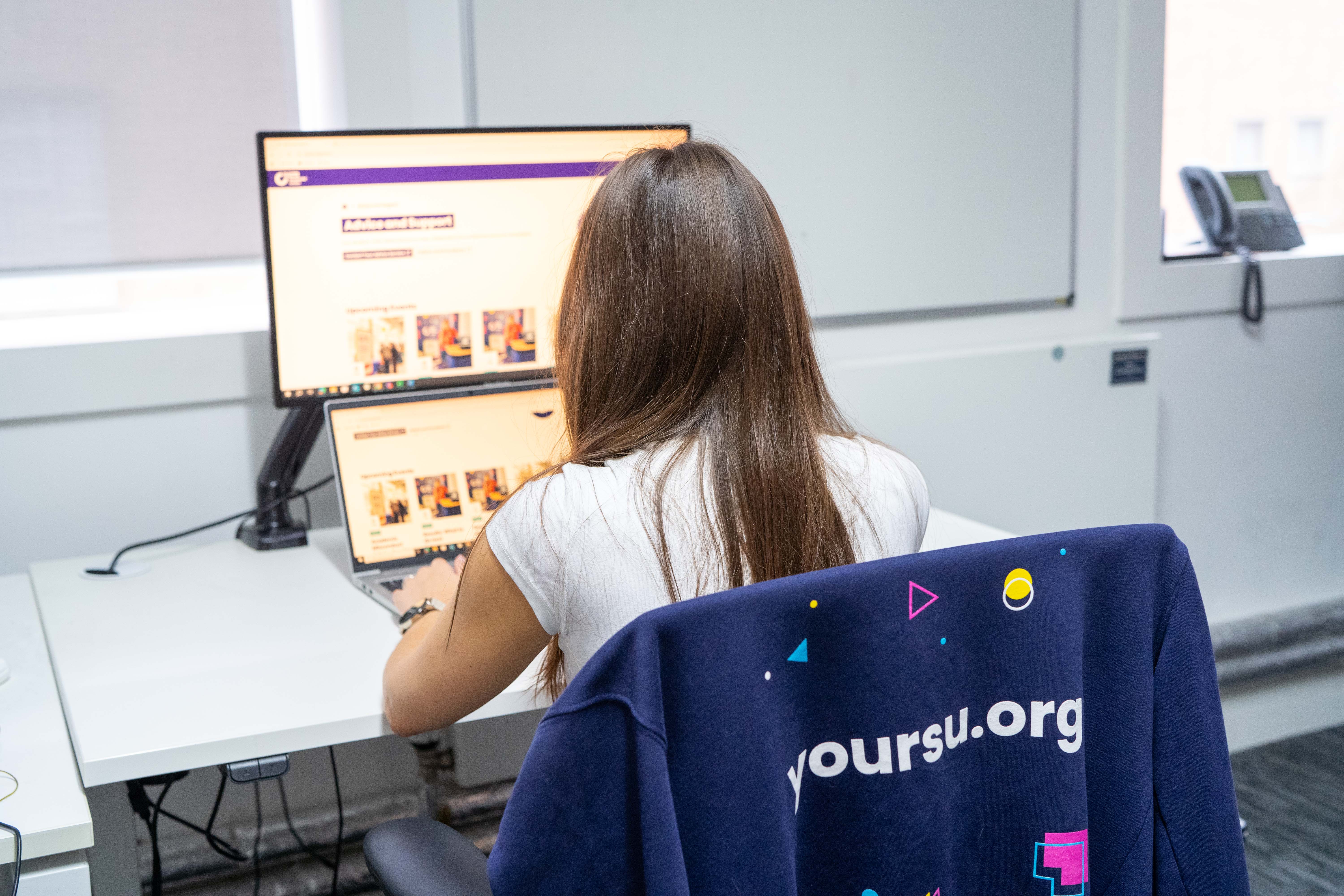 The back of a person using a laptop.