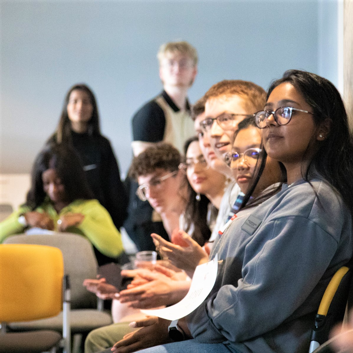 Students sat on chairs in a row looking past the camera