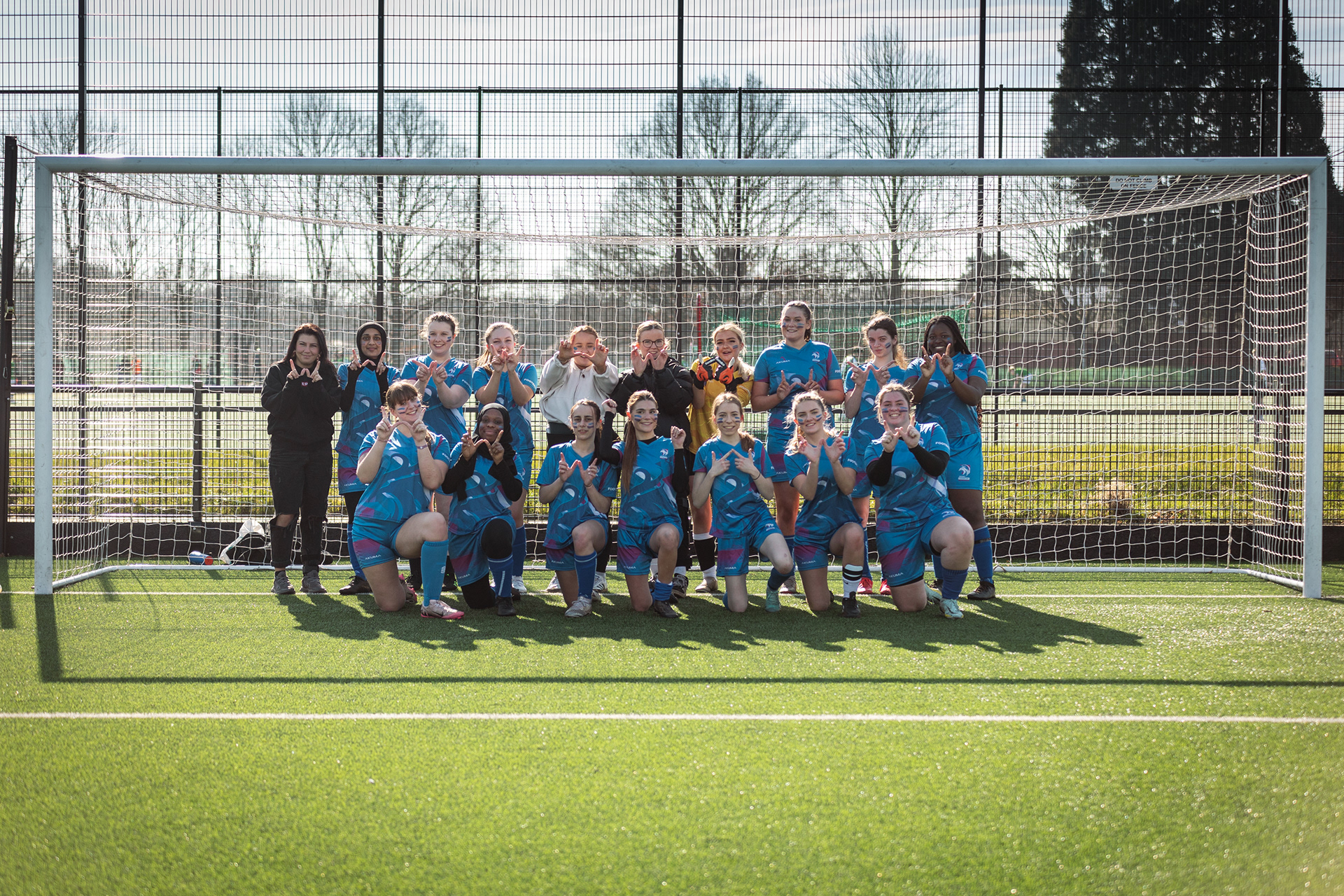 Four students laughing and smiling outside with a basketball