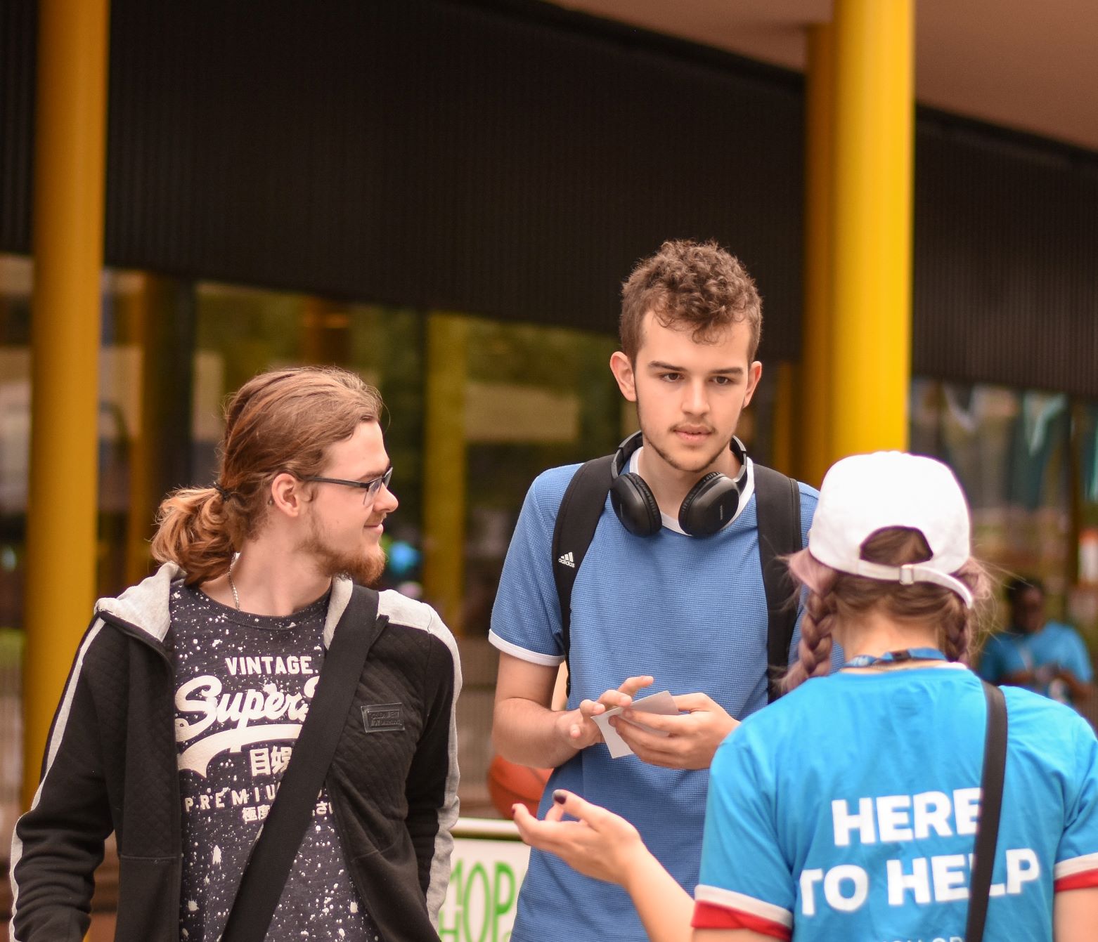 A student with here to help on her top with two students talking to her