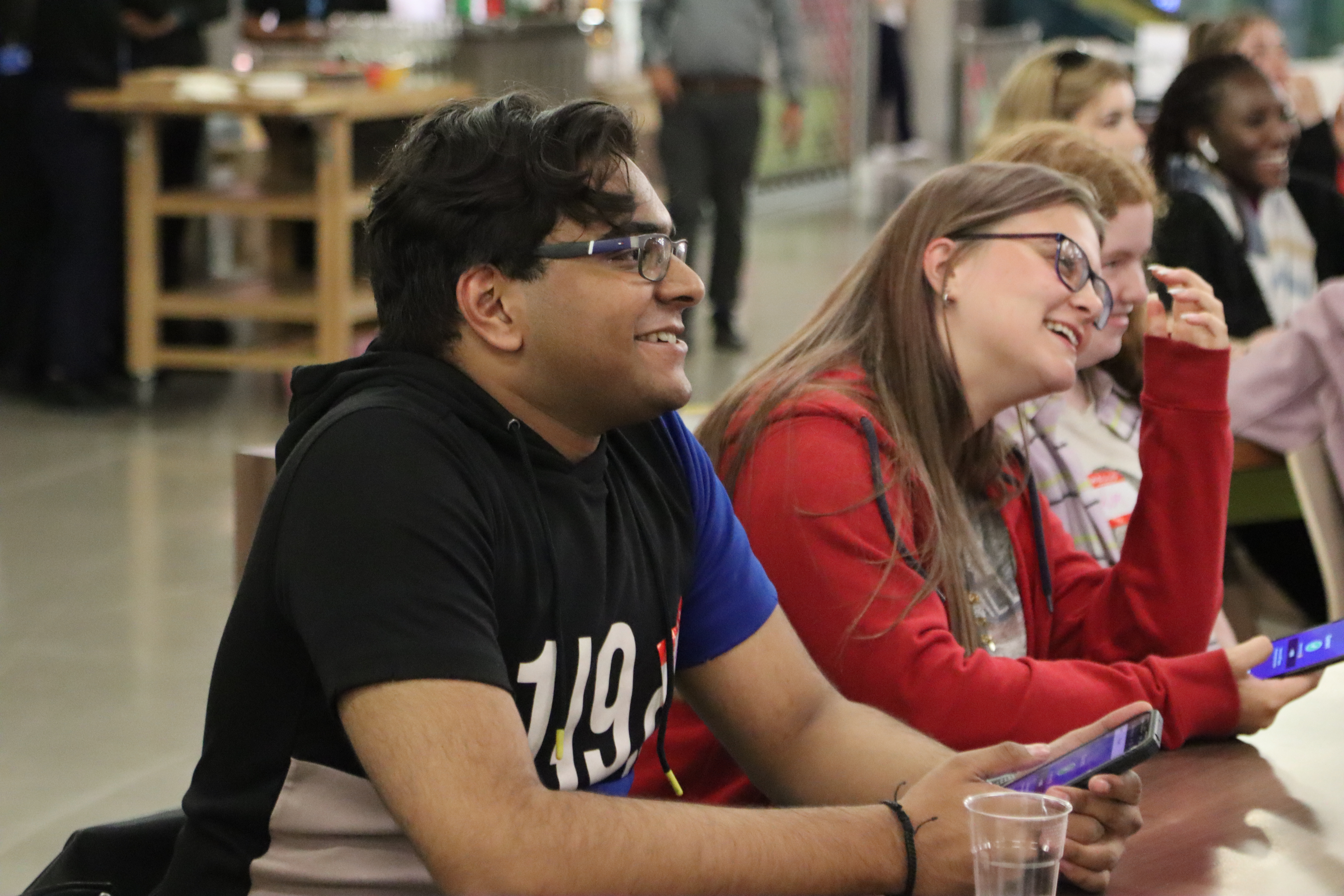 Four students and smiling during a lecture.